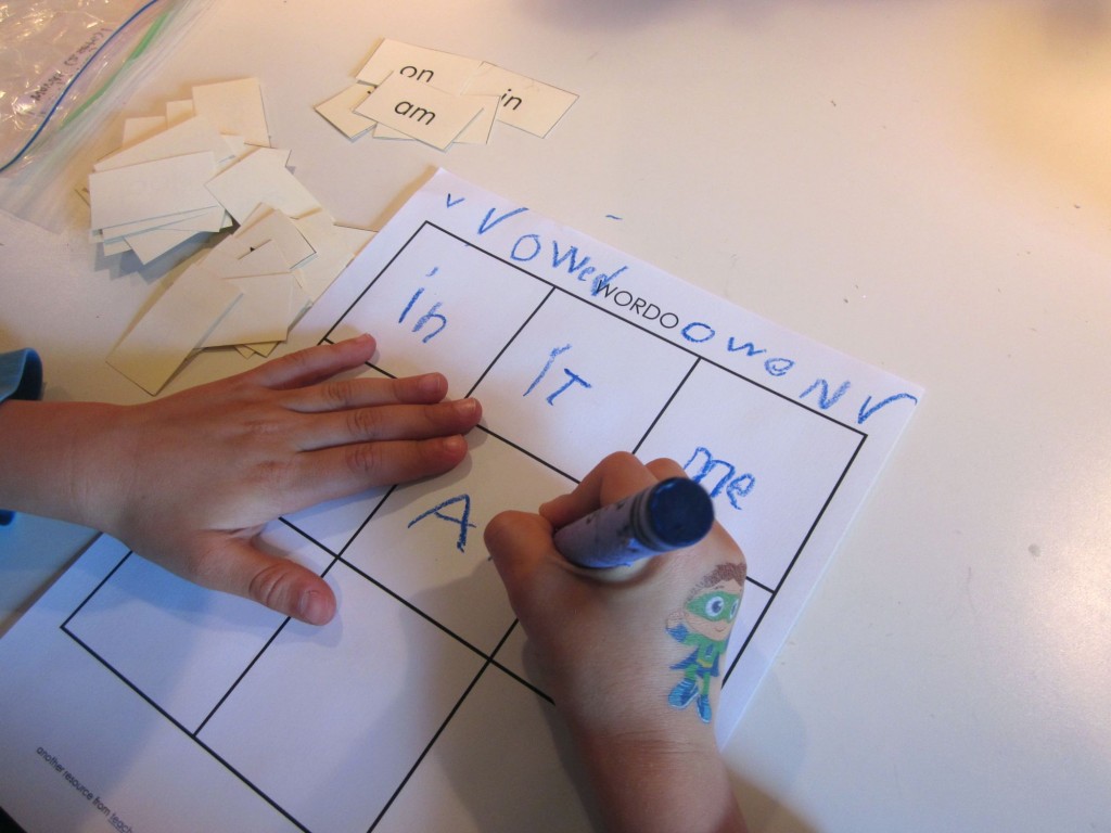 child writing sight words on bingo board