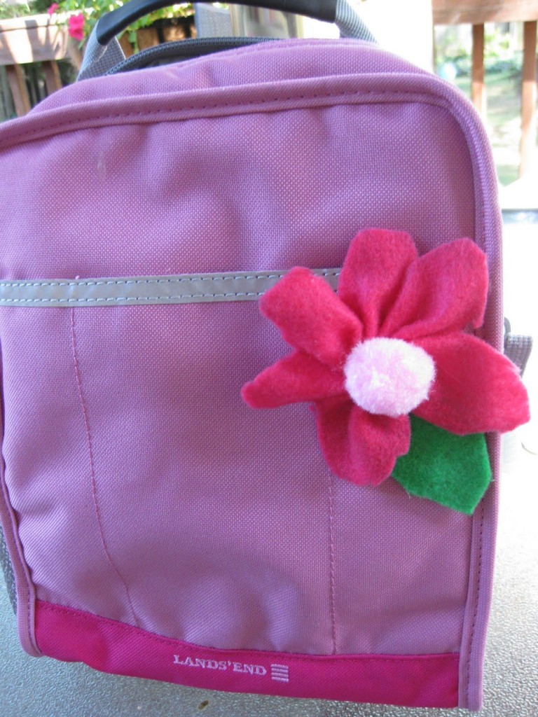 pink lunchbox with flower pinned to it