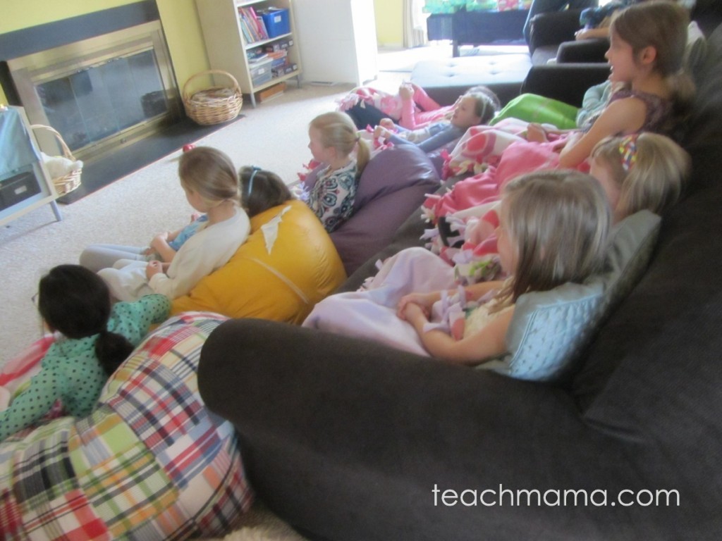 girls at frozen party cozy with blankets, watching movie