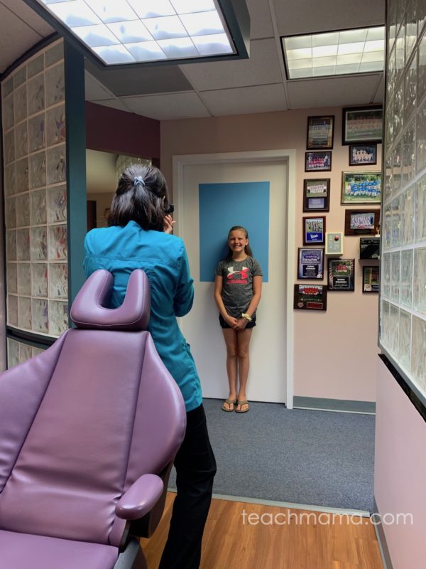 little girl standing by wall in orthodontist office