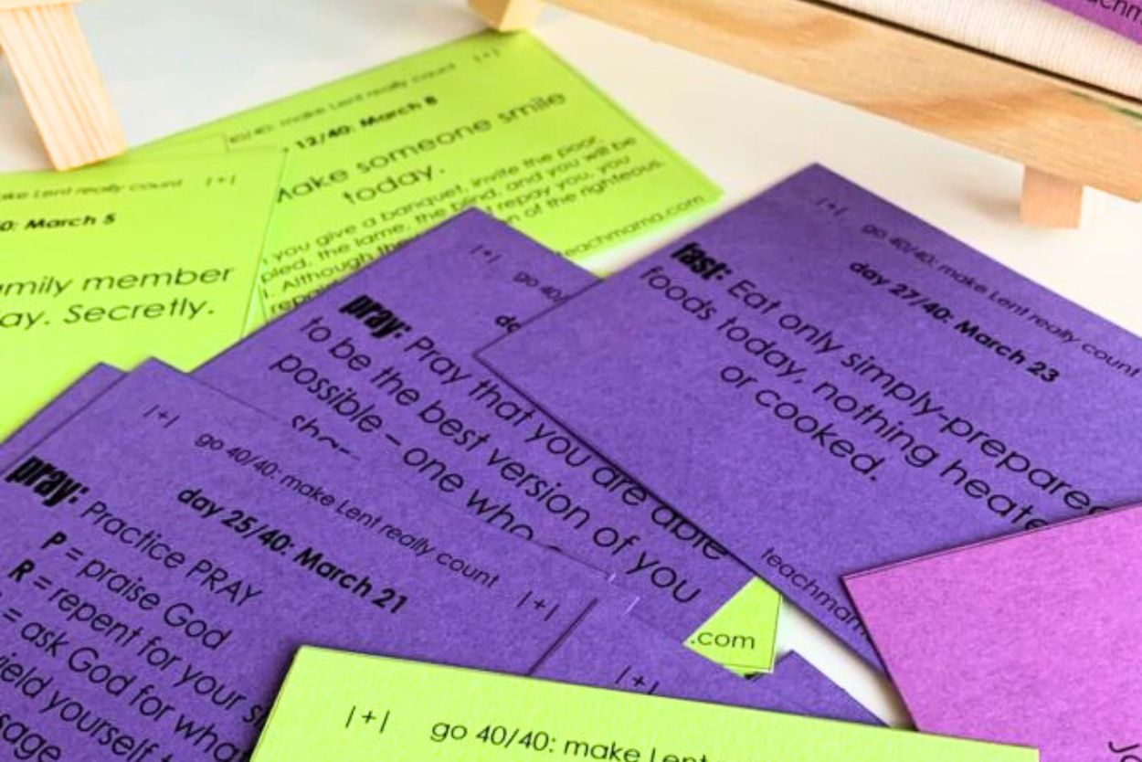 Lent cards for christian families printed in various colors and cut out for use, scattered across a table