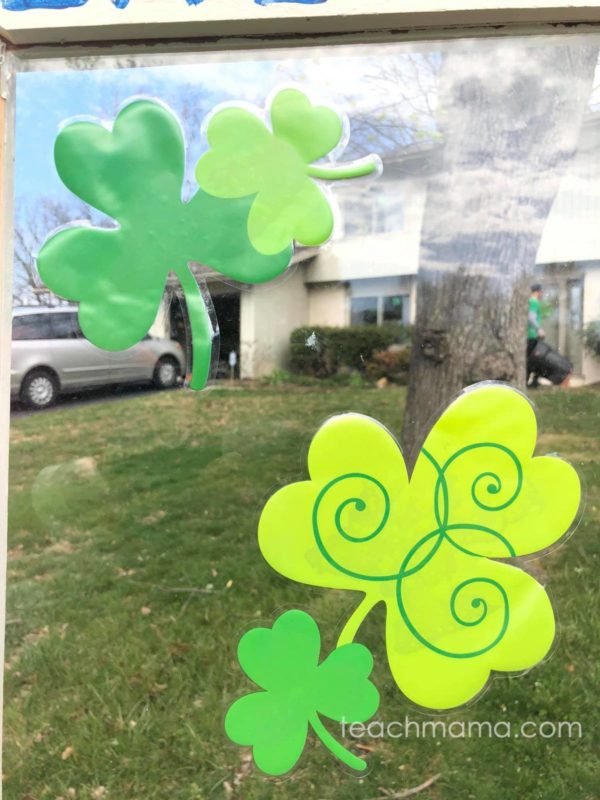 shamrocks on window of little free library in front of someone's house