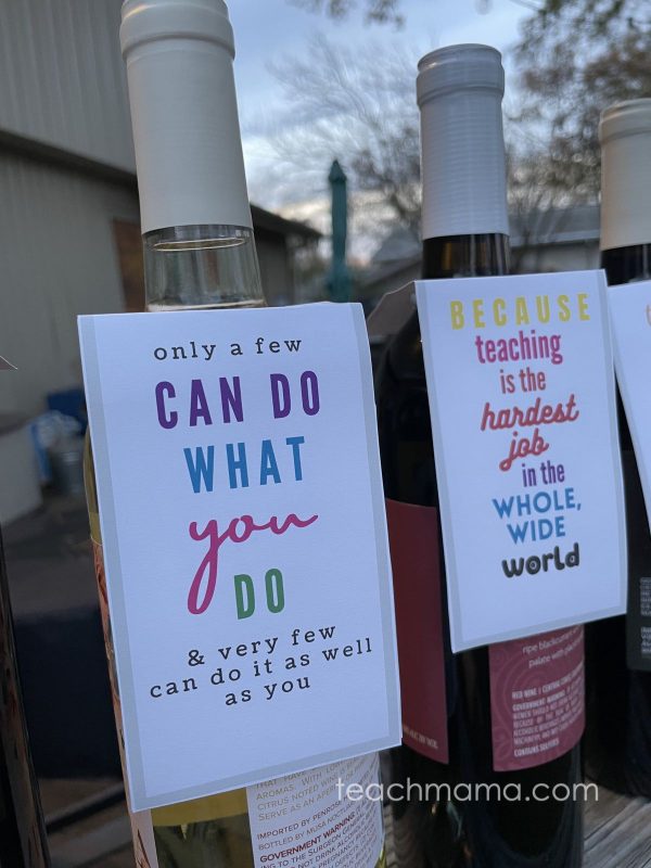 two wine bottles with tags that read positive sayings for teachers