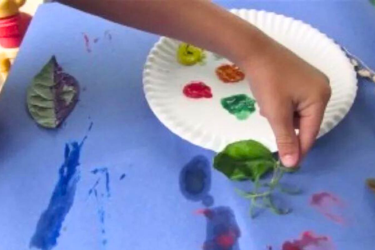 child painting with leaves and stems