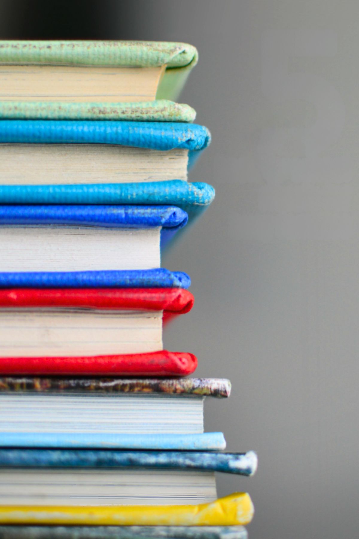 A stack of school books with primary color covers