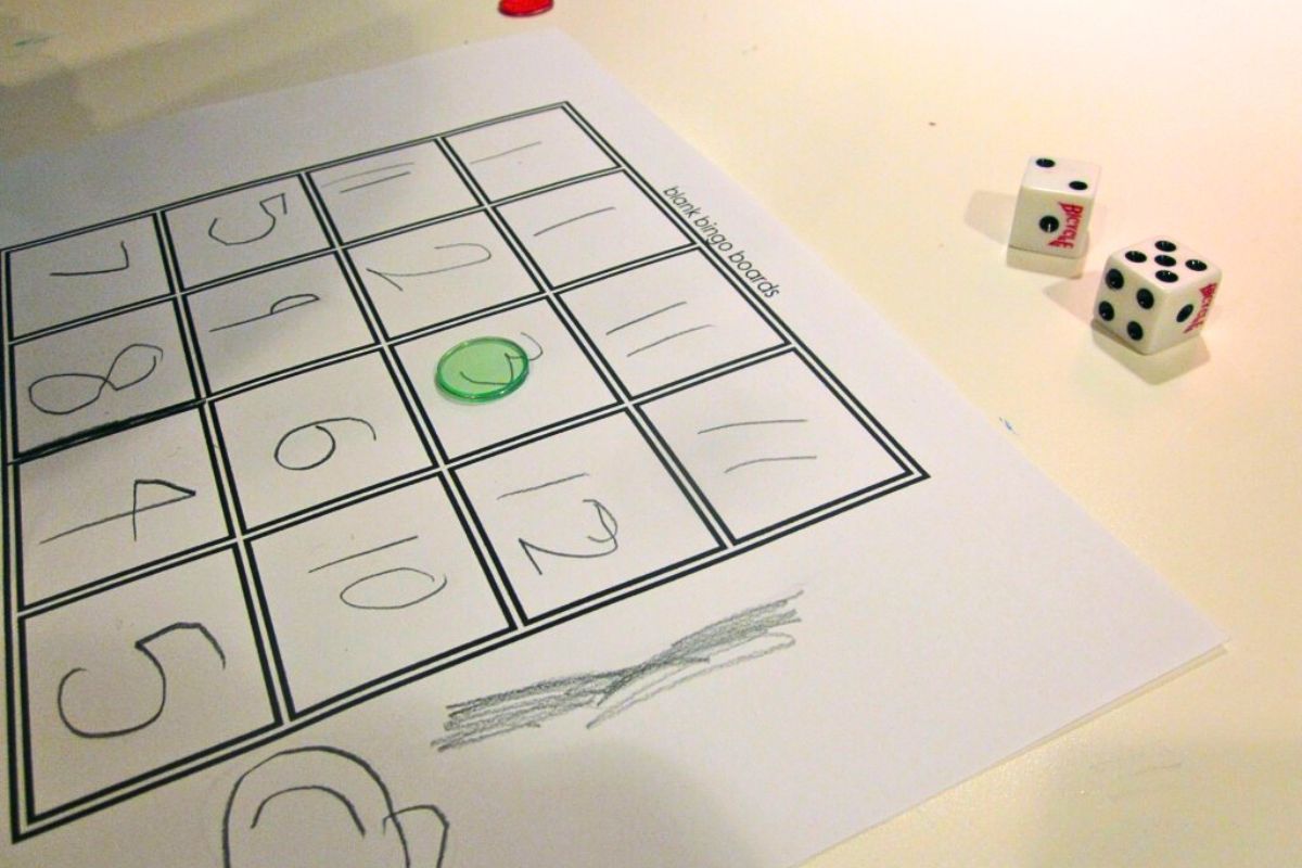 Grid game with hand written numbers, clear markers and a pair of dice.