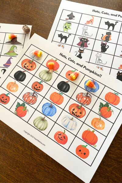 Printable grid game boards with colorful cartoon pumpkins and candy corn markers