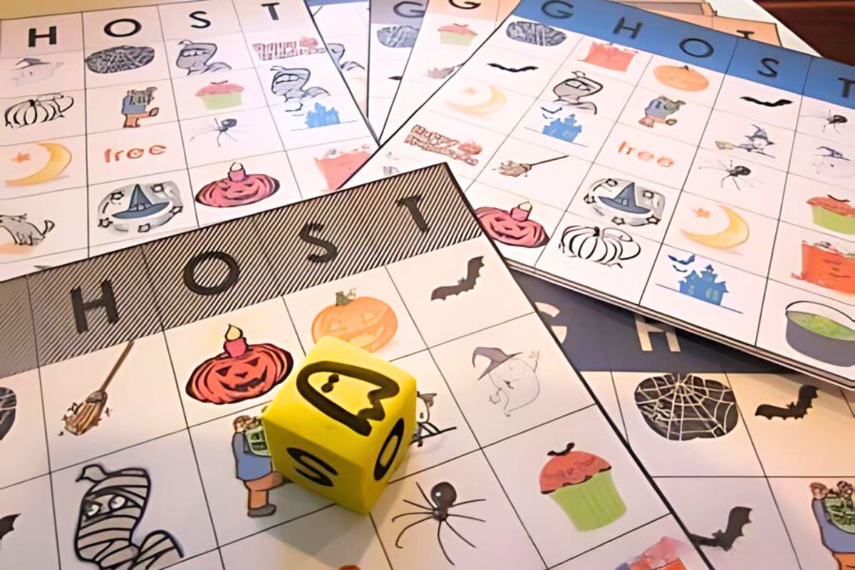 Boo bingo boards with ghosts, cupcake and other Halloween images with a yellow die