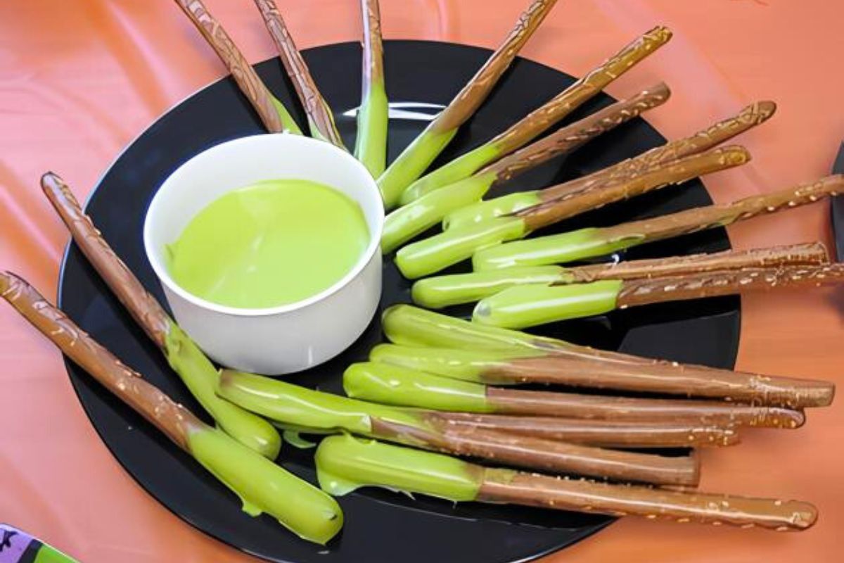 spooky halloween treats boogers on sticks, class party help for classroom parents Pretzel Sticks with Green Icing on one end arranged on a black plate
