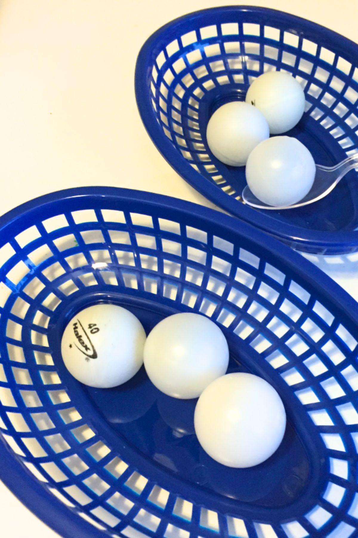 Ping pong balls in blue plastic baskets