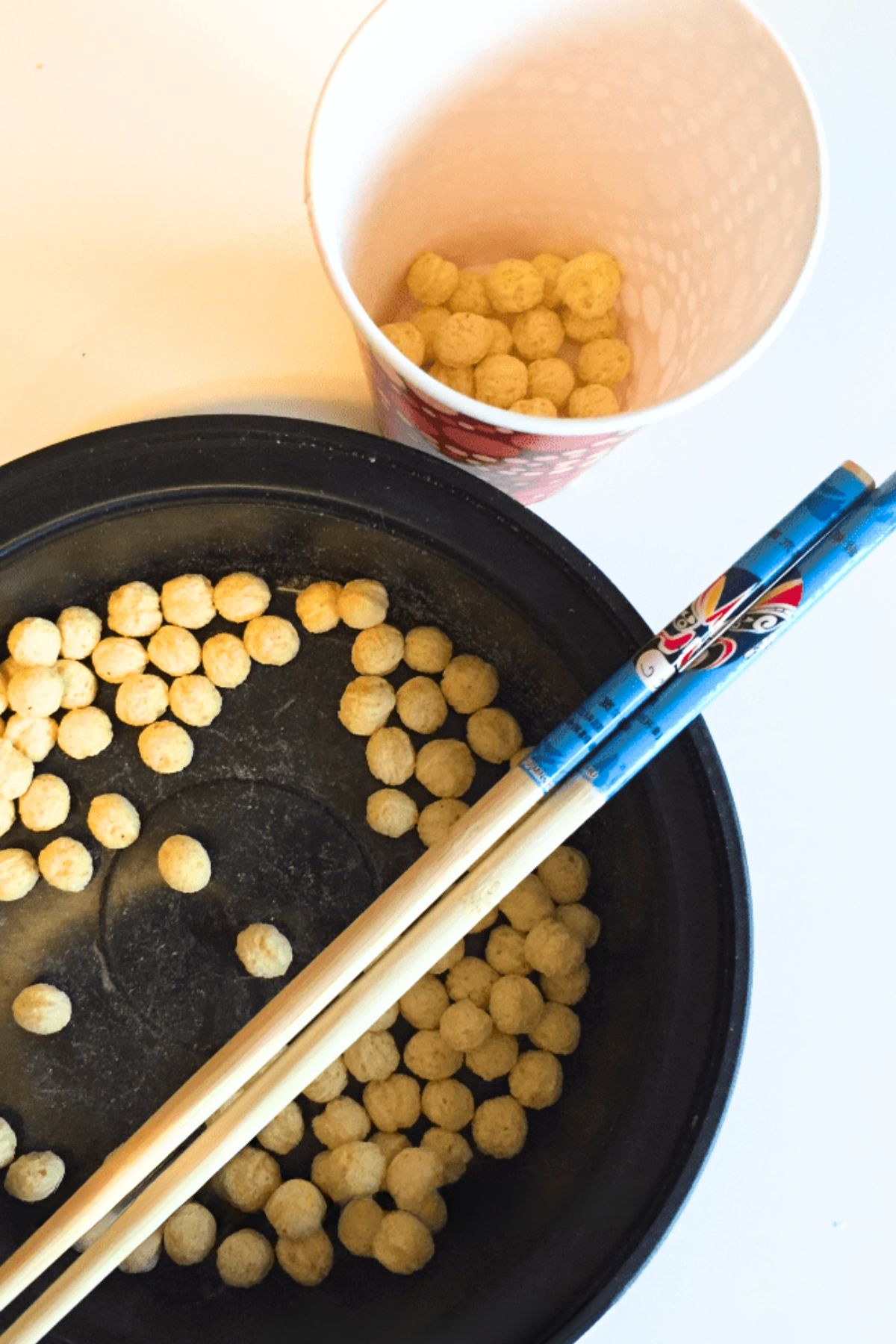 Kix cereal in a bowl with a pair of chopsticks
