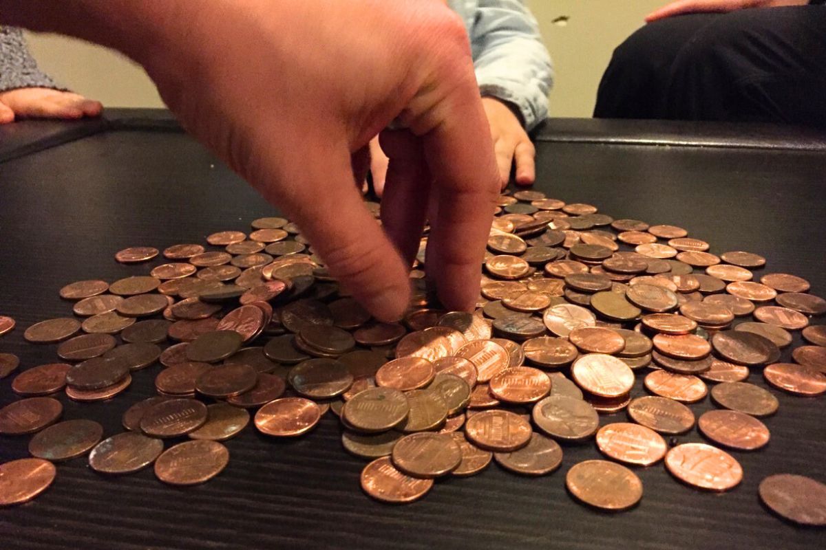 Hand picking pennies up from a stack