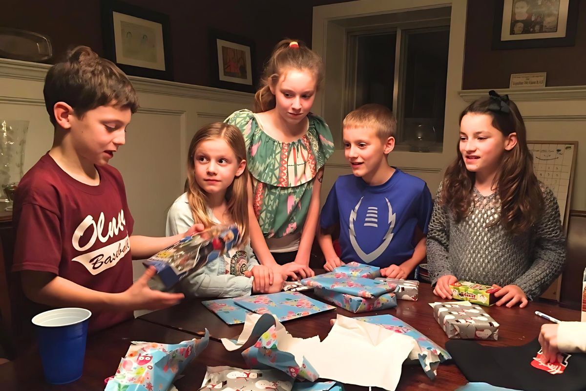 Children opening wrapped prizes around a wooden table