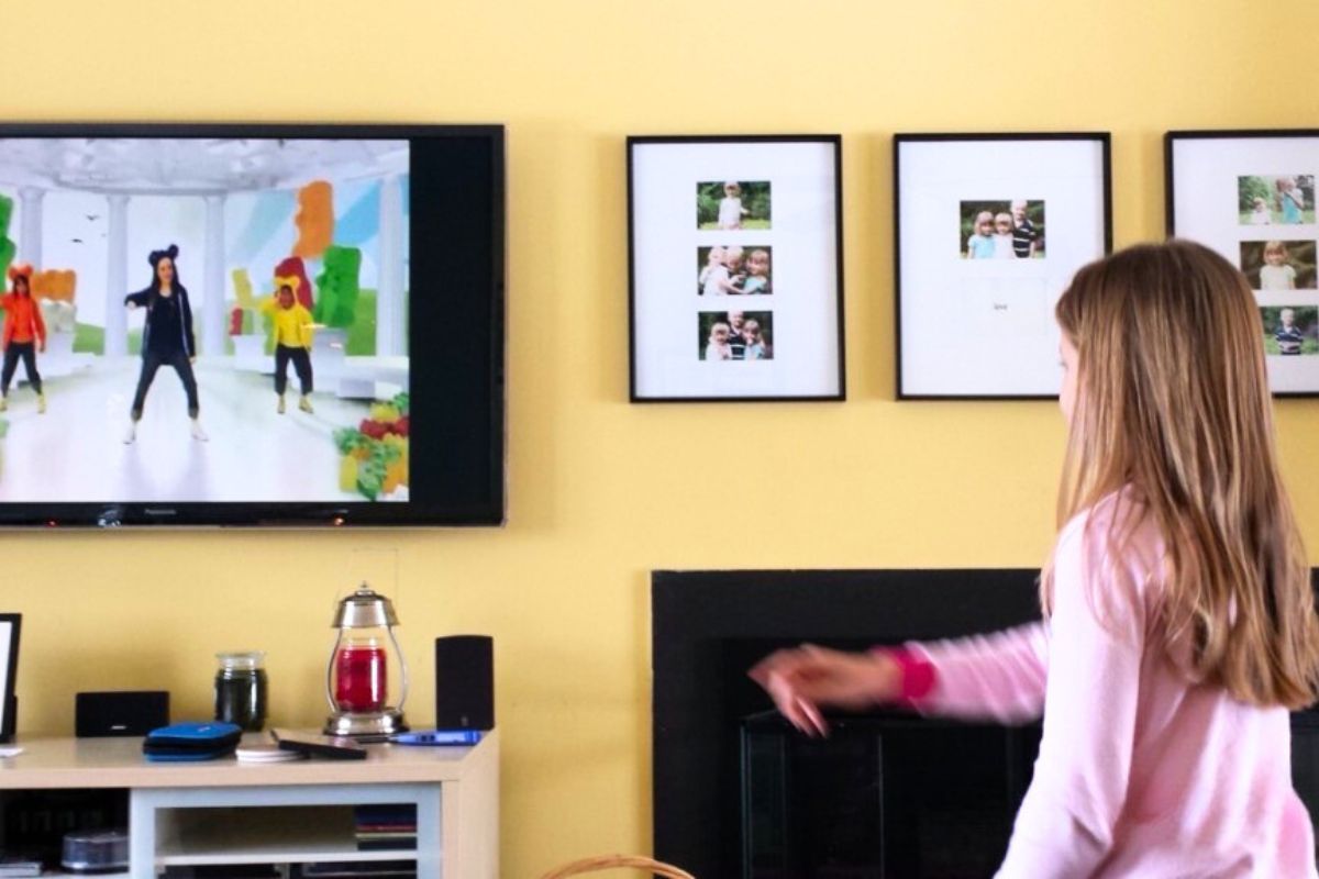 Girl in front of a television dancing to a children's dance video