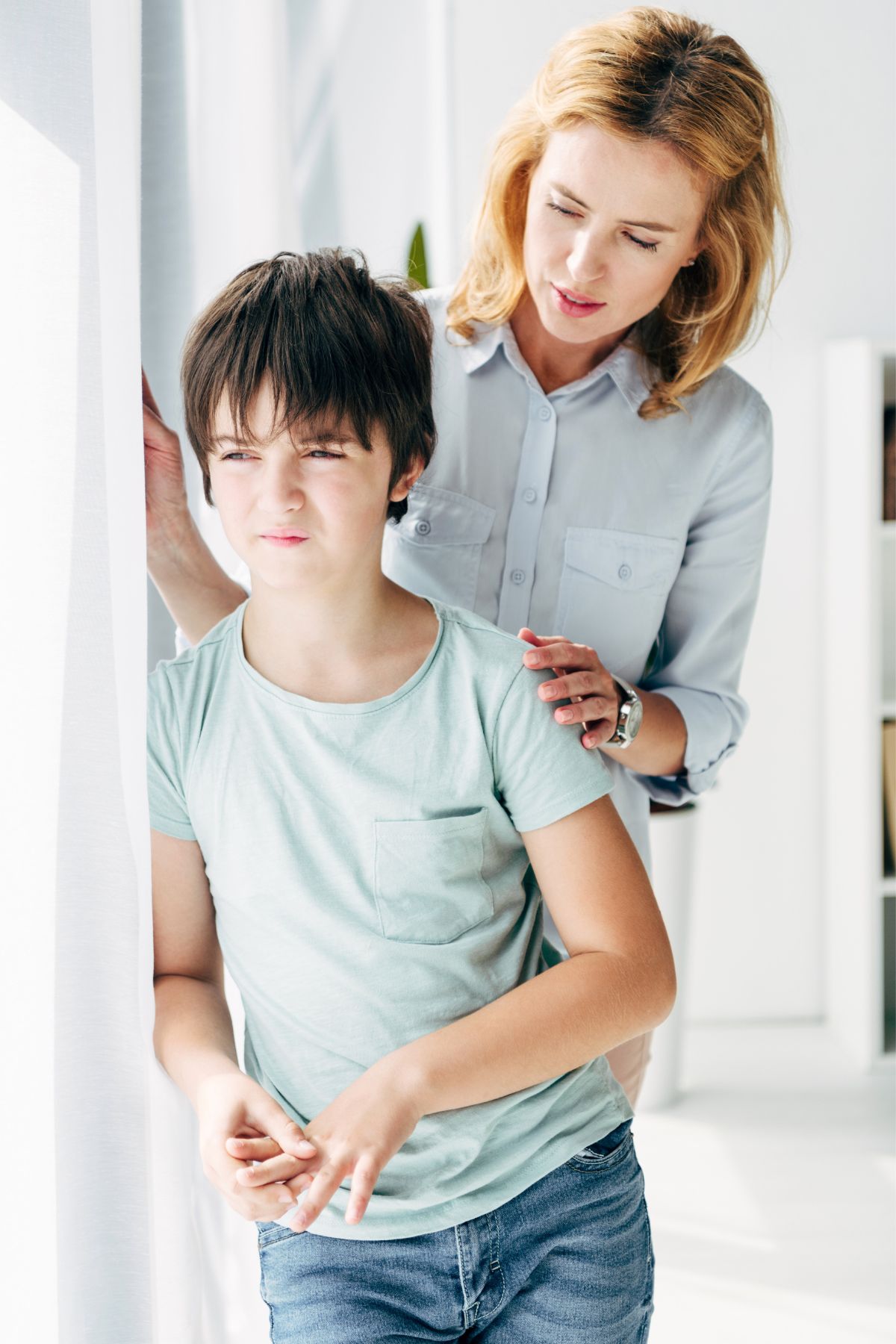 Mom standing behind son