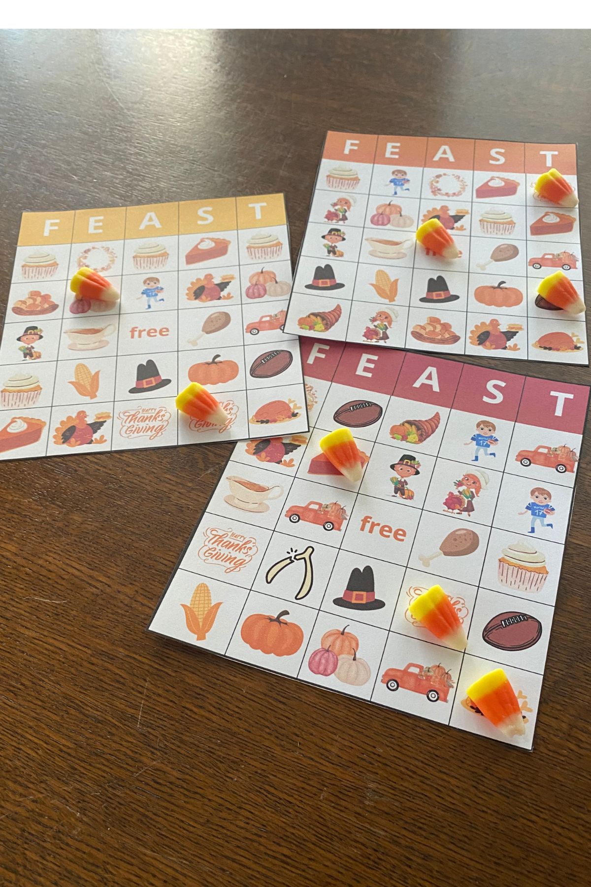 Three Thanksgiving themed Bingo boards on a wooden table