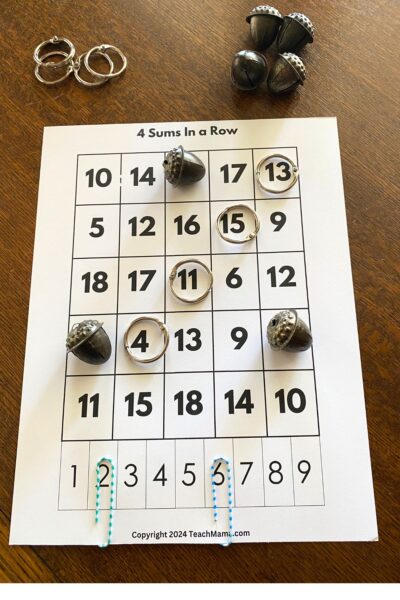 White cardstock with five columns of numbers with jump rings and metal acorns for markers