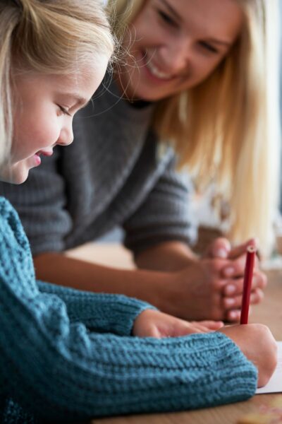Mother and daughter writing at a table