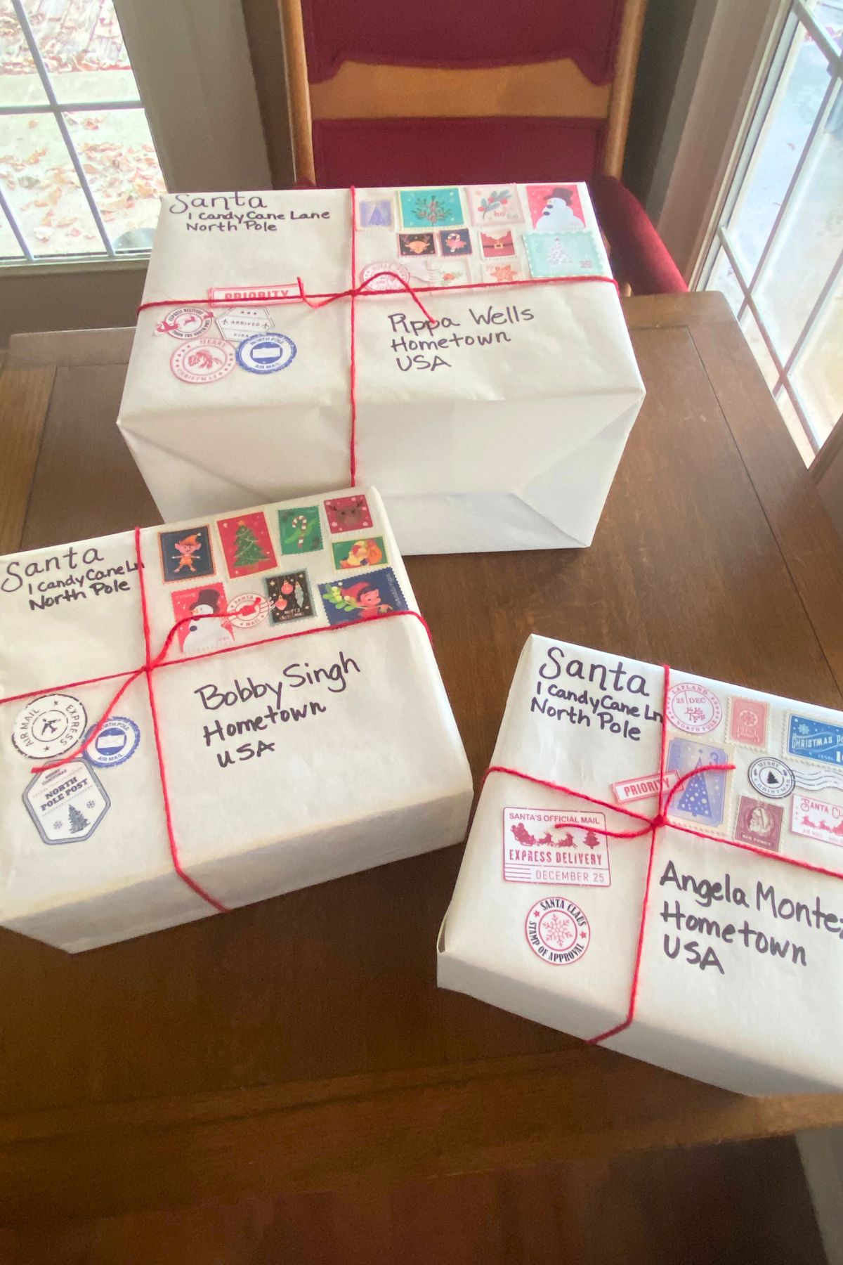 White boxes wrapped with red yarn ribbon and North Pole postal stamps and marks
