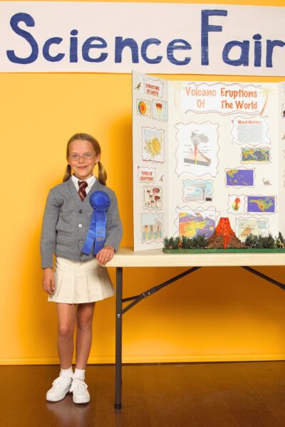 Young girl standing in front of a science fair project