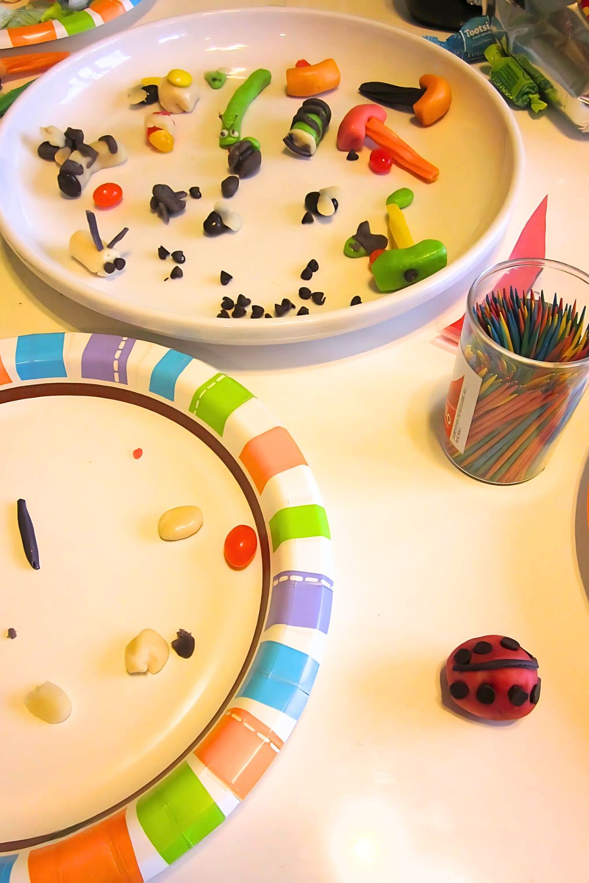 Lime chews, chocolate chips, Twizzlers and marzipan on a white plate