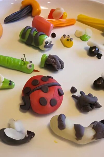 Candy caterpillars, ladybugs, worms and flies on a white plate