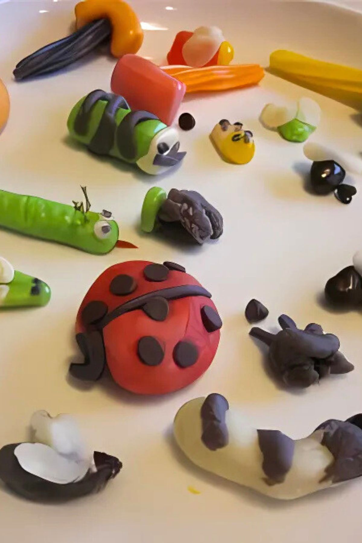 Candy caterpillars, ladybugs, worms and flies on a white plate