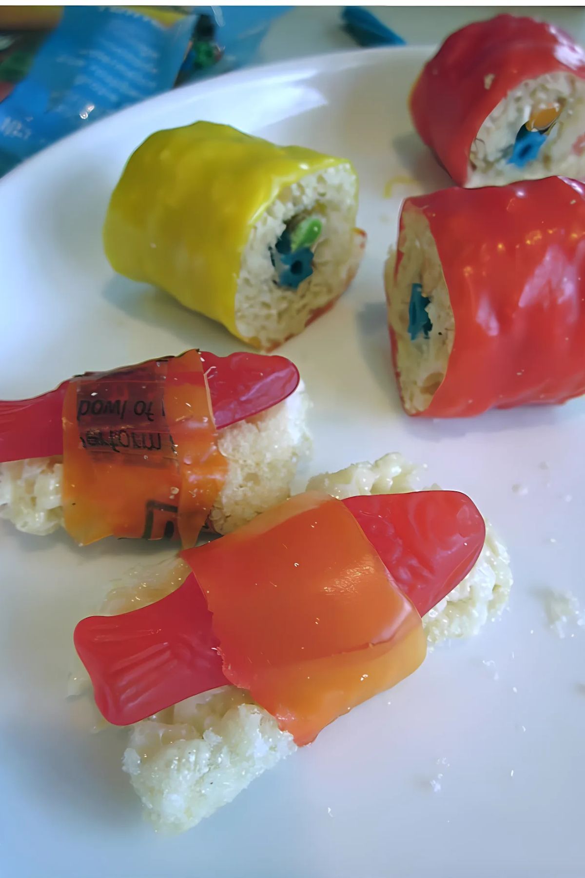 Gummy fish on Rice Krispy fake rice and rolled sushi made from Rice Krispies and fruit roll-ups with gummy fish in the center