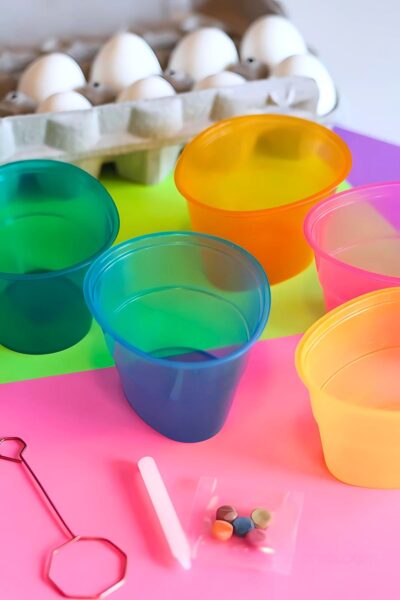 Egg carton with multi-colored egg dyeing cups on a table