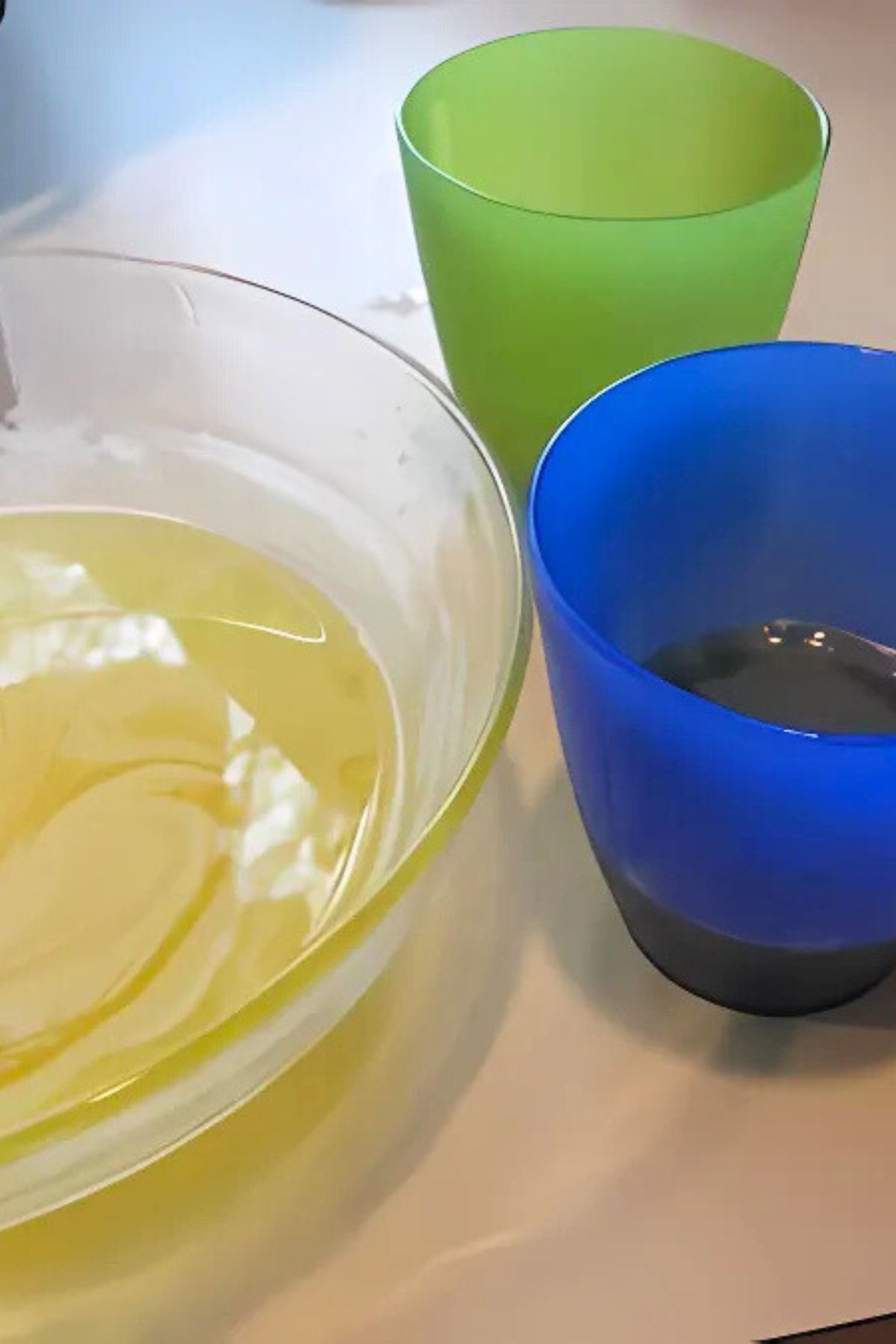plastic glasses and a clear glass bowl with lemon jello