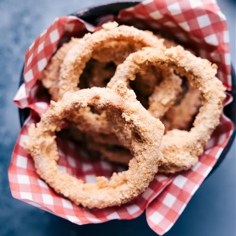 Fake onion rings in a basket with red checkered paper