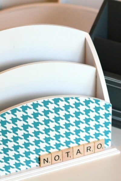 Wooden file holder with a blue and white front and Scrabble tiles spelling out a last name