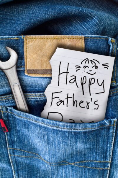 Handwritten Happy Father's Day Notes in a blue jeans back pocket along with a silver wrench