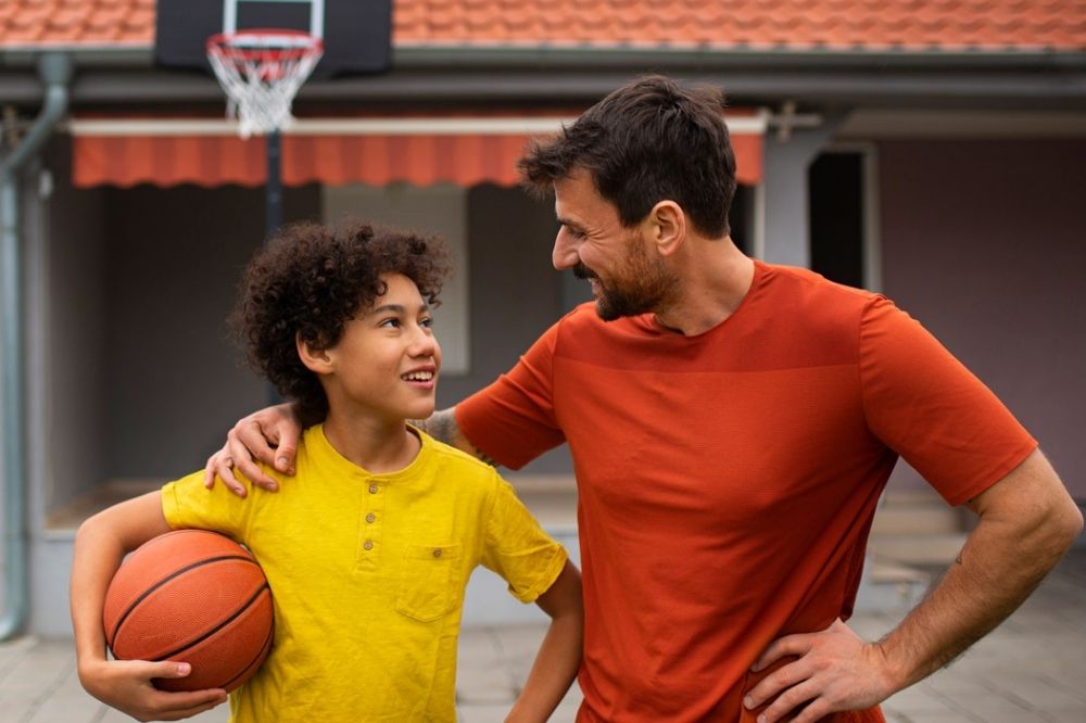 Father and son playing basketball together in the backyard