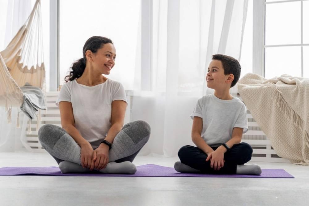 Woman and kid sitting on a mat