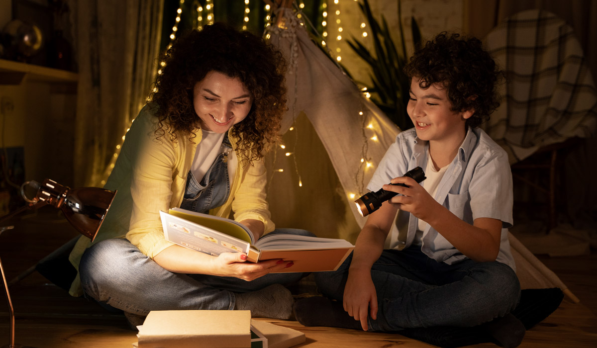 Close up on child reading with his parents 