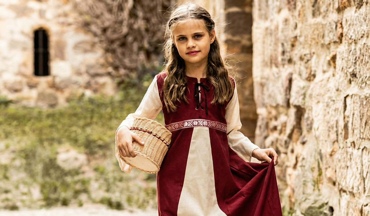 Girl in medieval dress holding a basket 