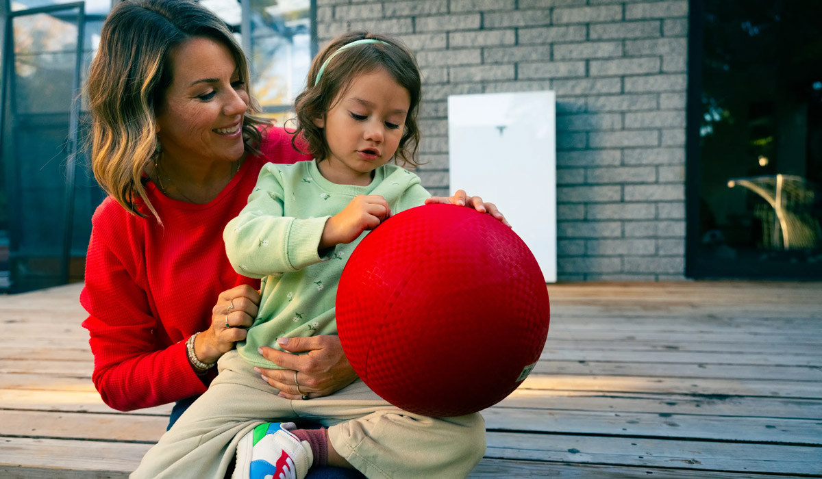 Mother and child with red ball on deck