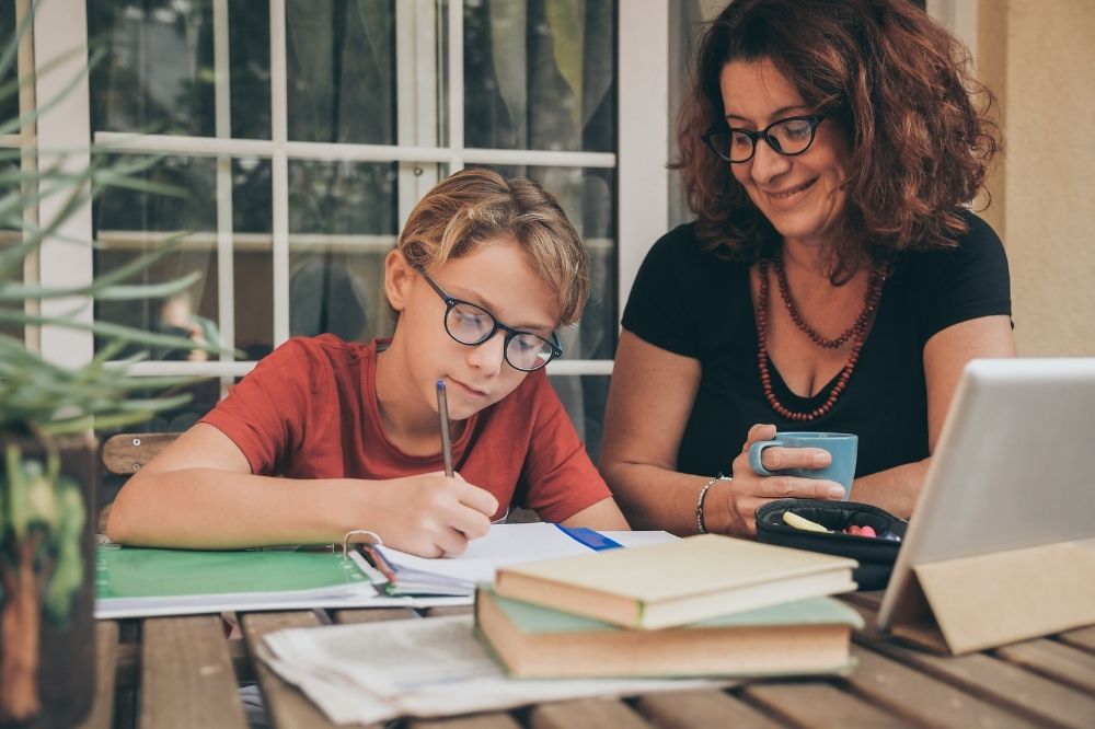 parent helping her kid to write