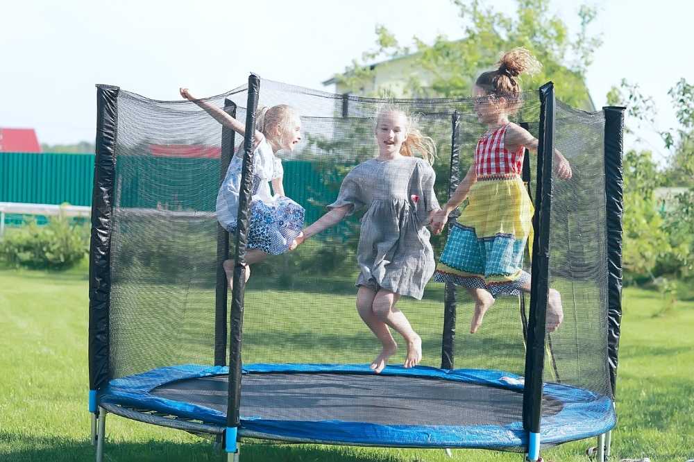 kids playing on the trampoline in the backyard